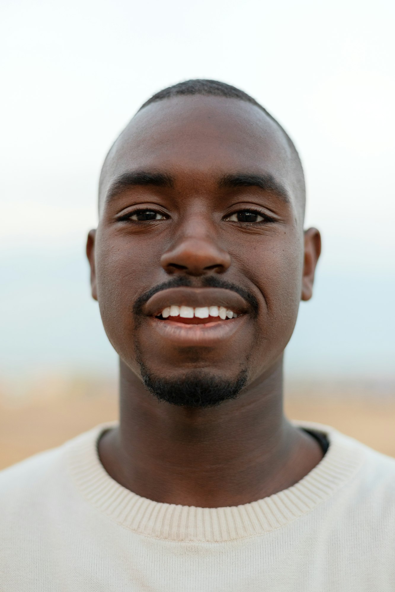 Vertical portrait of young African American man looking at camera. Headshot.